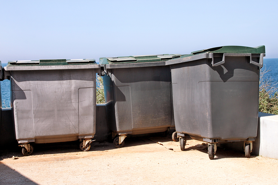 large garbage containers, trash dumpsters and bins standing in row.